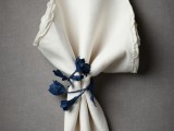 a neutral embroidered napkin with a navy fabric floral napkin ring is a very bold and cool idea