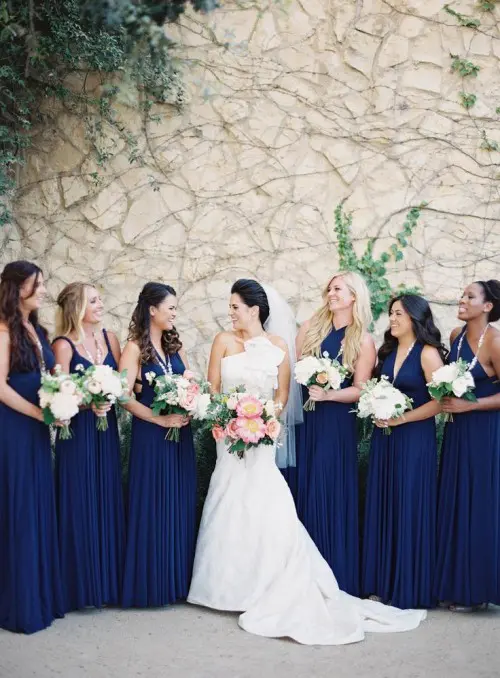 mismatching pleated navy maxi bridesmaid dresses paired with white bouquets create a chic contrasting look