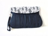 a navy draped clutch with white lace is an elegant and chic accessory for a bride or bridesmaids