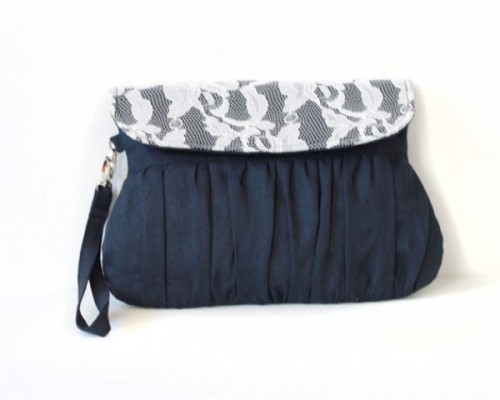 a navy draped clutch with white lace is an elegant and chic accessory for a bride or bridesmaids