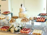 a simple and elegant dessert table styled with a white tablecloth, with glass and silver sweet holders looks chic
