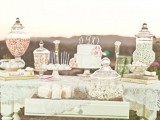 an elegant vintage dessert table with doilies, large jars, vintage stands on a simple table looks chic and elegant