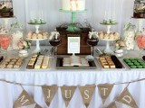 a rustic wedding dessert table with burlap garlands, faux nests, cages and colorful sweets