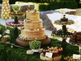 a whimsy woodland dessert table with a moss tablecloth, woodland stands with sweets, a bark wedding cake
