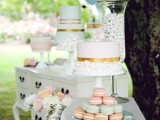 an elegant vintage dessert table composed of two white sideboards and simple white stands for sweets