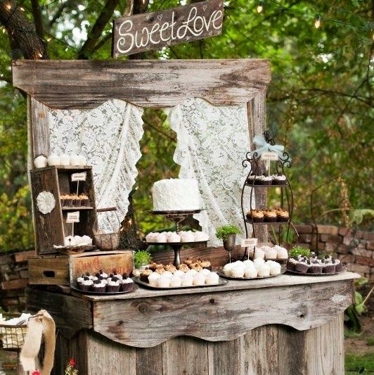 A rustic wedding dessert table of weathered wood, with crates and boxes and lots of sweets