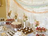 a white wedding dessert table with a newspaper backdrop plus pastel garlands for a vintage feel