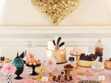 a chic dessert table in black and white stripes, with a pink countertop plus a gold sequin heart over it for more romance