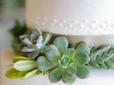 a white buttercream wedding cake decorated with greenery and succulents placed on the tiers is a lovely idea for a modern neutral wedding