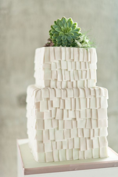 a creative white buttercream square pieces wedding cake topped with succulents is a whimsical and lovely idea for a modern wedding, with plenty of geometry