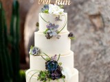 a white buttercream wedding cake decorated with greenery, succulents, white blooms and a calligraphy topper is a lovely idea for a wedding