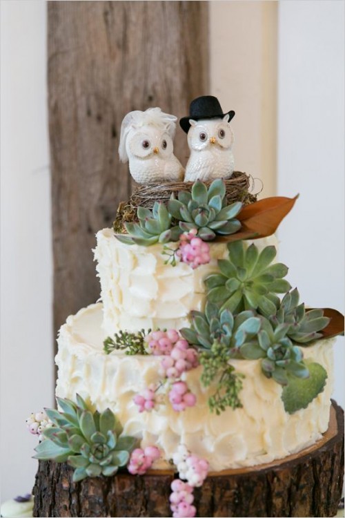 a neutral textural buttercream wedding cake decorated with lots of succulents, berries, a nest with owls for a cute touch