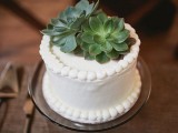 a small white wedding cake topped with sugar beads and with succulents is a pretty and edgy idea for a small wedding