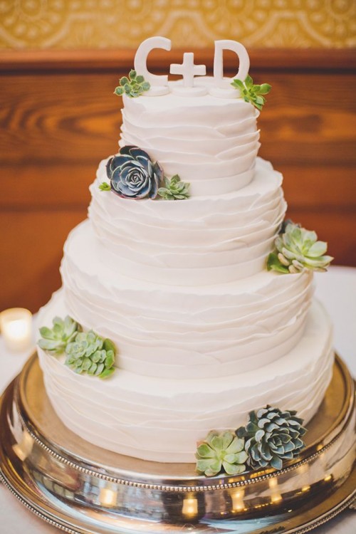 a white ruffle tiered buttercream wedding cake decorated with succulents and with monogram cake toppers is a stylish idea to rock at a rustic wedding