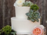 a sleek white buttercream wedding cake decorated with succulents, moss and neutral blooms is a stylish idea for a modern wedding