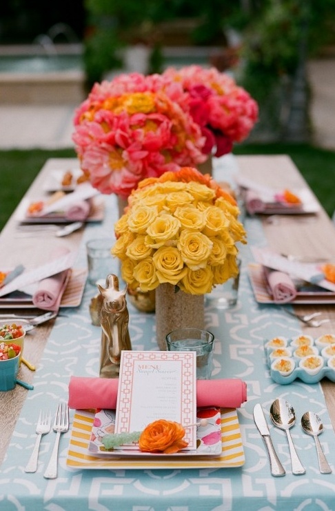 a colorful summer tablescape with a printed runner, bright blooms, pastel linens for a bold and cool space