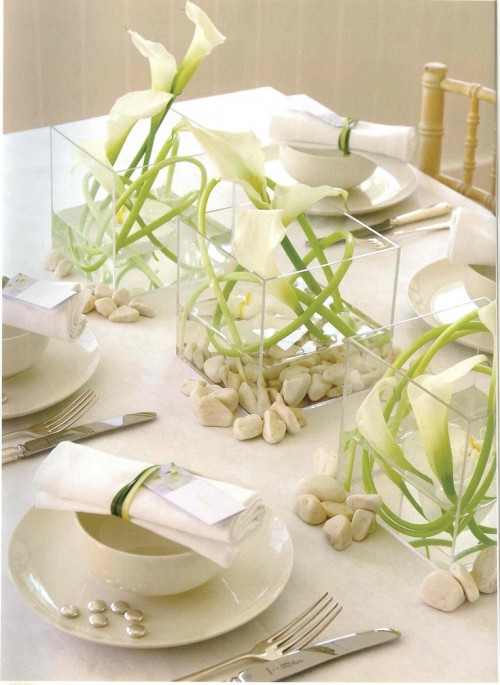 a neutral summer wedding tablescape with white florals in square vases, with neutral linens, simple porcelain and cutlery