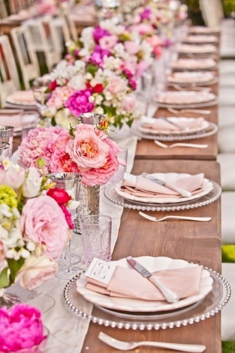 a bright elegant summer wedding tablescape with neutral linens, bright blooms and greenery and pink linens