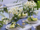a bright and relaxed summer tablescape with a plaid runner and yellow napkins, neutral blooms and candles is ideal for a relaxed summer wedding