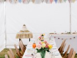 a bright summer wedding tablescape with colorful buntings, bright blooms and napkins and a neutral table runner for a bold summer wedding