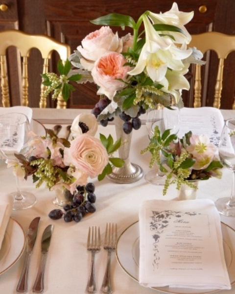 a refined summer wedding table setting with neutral linens and tender pastel and neitral blooms and greenery plus fresh fruits