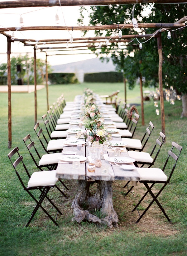 a neutral rustic wedding tablescape with neutral blooms, greenery and succulents plus neutral linens and cutlery
