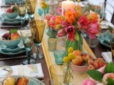 a vivacious summer wedding tablescape with a printed runner, blue porcelain, bright blooms, candles and blue glasses