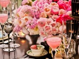 an exquisite bright summer wedding tablescape with super lush pink florals, candles and macarons