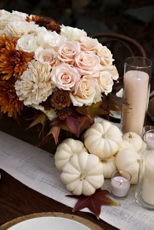 a chic fall or Thanksgiving tablescape with rust and blush blooms, blush candles and white pumpkins is a great idea