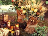 a rustic fall or Thanksgiving sweets table with candles, floral and greenery arrangements and some wheat is a very cool and fresh idea