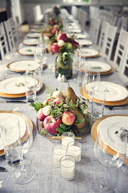 a neutral fall or Thanksgiving wedding tablescape with bold fruit and greenery centerpieces and neutral linens