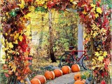 a super lush Thanksgiving and fall wedding arch fully covered with bright fall leaves and greenery and with pumpkins lining up the aisle is amazing
