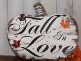 a plywood pumpkin sign with ‘fall in love’ words is a cool decoration for Thanksgiving and any parties connected to it