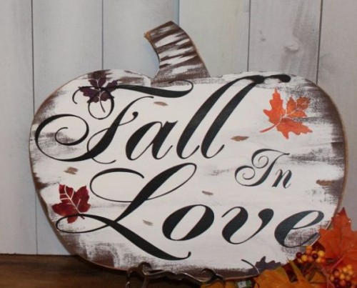 a plywood pumpkin sign with 'fall in love' words is a cool decoration for Thanksgiving and any parties connected to it