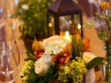 a fall or Thanksgiving wedding centerpiece of a tree stumps with neutral and bold blooms and greenery is chic