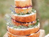 a naked wedding cake topped with lavender, some wildflowers and a pinecone is a lovely idea for a summer or fall wedding, looks delicious