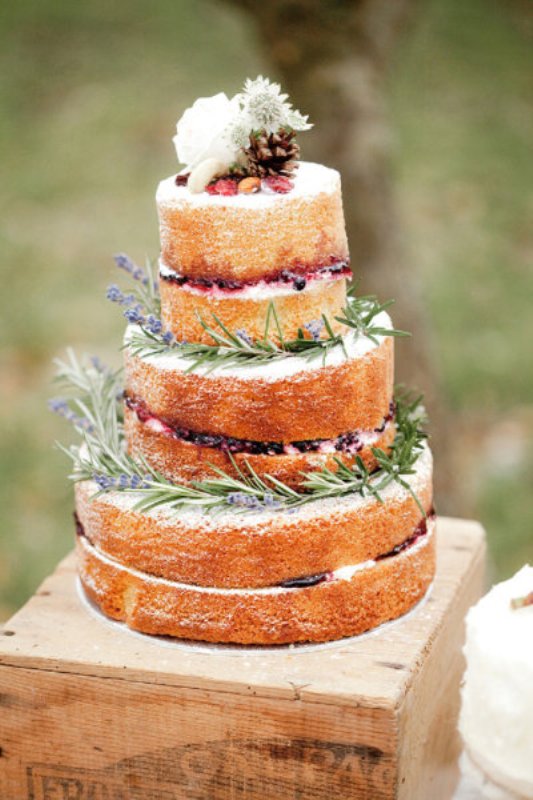 a naked wedding cake topped with lavender, some wildflowers and a pinecone is a lovely idea for a summer or fall wedding, looks delicious