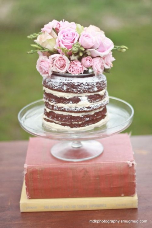 a chocolate naked wedding cake topped with white and pink roses and greenery is a fabulous idea for a spring or summer wedding