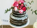 a naked chocolate wedding cake with pink and red roses and greenery is a fantastic idea for a spring or summer wedding