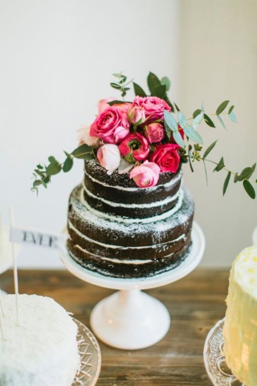a naked chocolate wedding cake with pink and red roses and greenery is a fantastic idea for a spring or summer wedding
