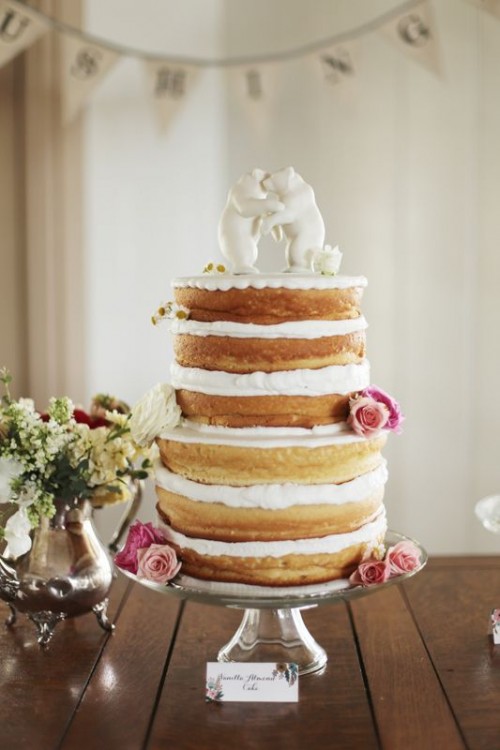 a naked wedding cake with lots of frosting and sugar cake toppers is a fantastic idea for a spring or summer wedding