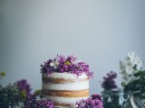 a naked wedding cake topped with lilac and white blooms is a lovely and delicate idea for a spring wedding
