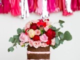 a chocolate naked wedding cake with pink frosting and pink, neutral and burgundy roses on top plus greenery is a fantastic idea for a summer wedding