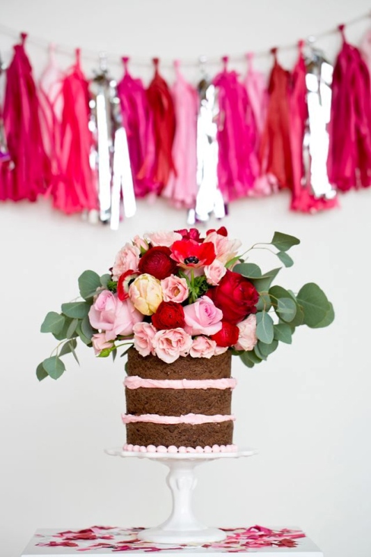 a chocolate naked wedding cake with pink frosting and pink, neutral and burgundy roses on top plus greenery is a fantastic idea for a summer wedding