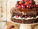 a naked chocolate wedding cake with chocolate on top, fresh berries inside and on top the cake is a lovely idea for a summer or fall wedding