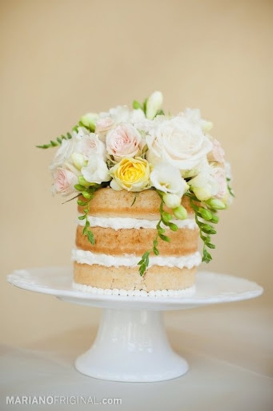 a naked wedding cake topped with neutral, blush and yellow greenery is a lovely idea for spring and summer