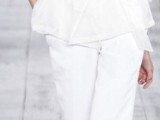 an ethereal white pantsuit with a top, white pants, a sheer jacket with long sleeves and silver heels for a modern casual bride