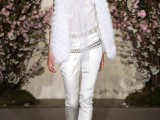 a whimsical bridal suit with a semi sheer top, white silk pants, a white faux fur coverup and white shoes