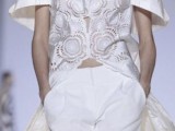 a whimsical bridal pantsuit with white palazzo pants and a cut out oversized top with short sleeves and a train