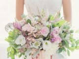 a delicate oversized wedding bouquet made of white and pink blooms, greenery and long peachy ribbons for a garden bride